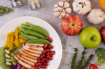 Sliced ​​chicken steak with peas, tomatoes, kiwi and pumpkin.