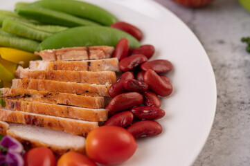 Sliced ​​chicken steak with peas, tomatoes, kiwi and pumpkin.