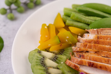 Sliced ​​chicken steak with peas, tomatoes, kiwi and pumpkin.