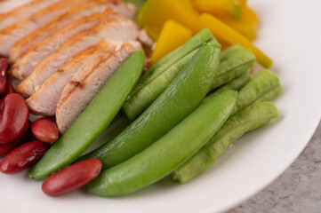 Sliced ​​chicken steak with peas, kiwi and pumpkin. Selective focus.