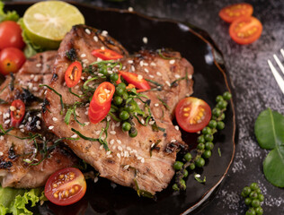 Sliced ​​pork steak topped with white sesame and fresh pepper seeds along.