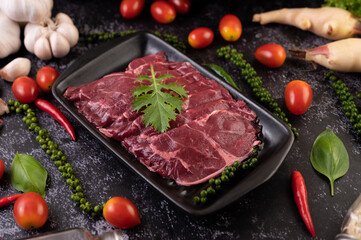 Sliced ​​raw pork used for cooking with chili, tomato, basil, and fresh pepper seeds.