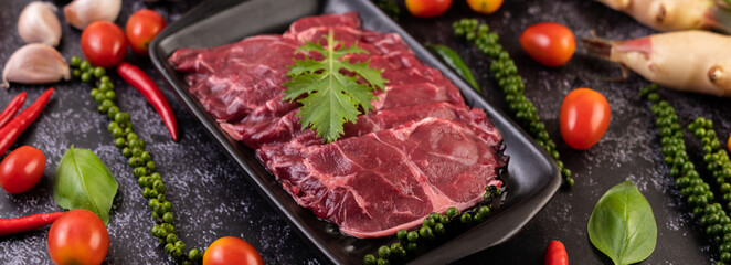 Sliced ​​raw pork used for cooking with chili, tomato, basil, and fresh pepper seeds.