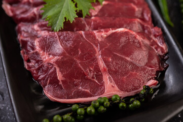 Sliced ​​raw pork used for cooking with chili, tomato, basil, and fresh pepper seeds.