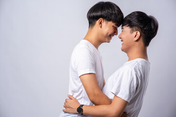 Two men who love each other happily hug each other.