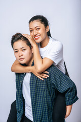 Obraz premium Two loving women wore striped shirts and rode their backs.