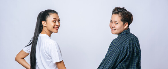 A woman of two lovers stood hand in hand and looked back and turned.