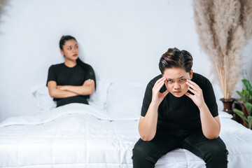 A woman who loves each other gets angry and sits on the bed.