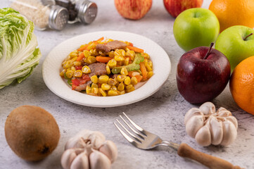 Stir the corn and carrots, put the pork on the plate on the wooden plate.