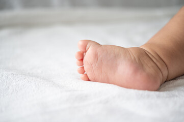 Baby feet in white bed.