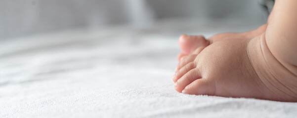 Baby feet in white bed.