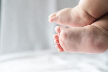 Baby feet in white bed.