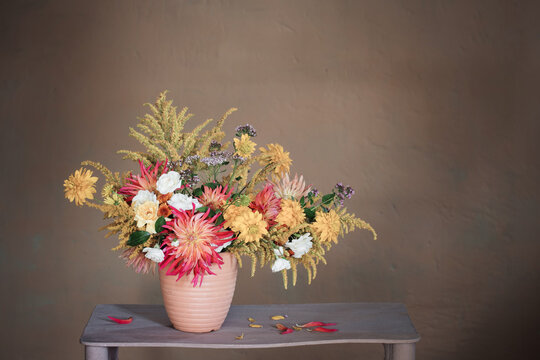 Yellow And Red Flowers In Vase On Vintage Shelf