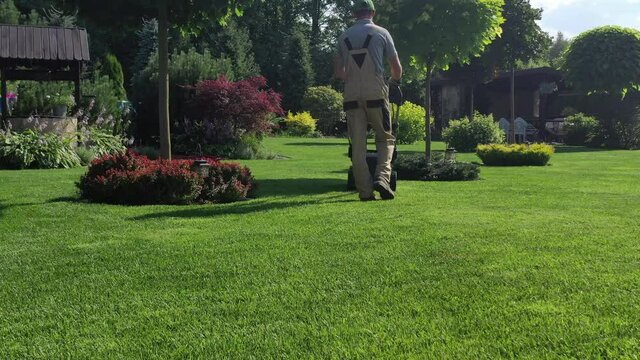 Curvy Rocky Pathway With Flat Round Pavers In Middle Of Large Green Lawn Surrounded By Mature And Established Abundant Landscape Design. 