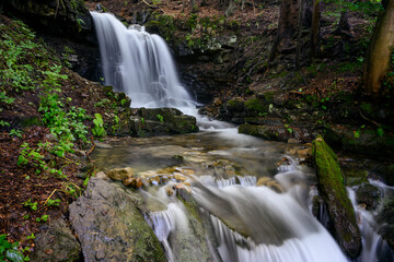 Naklejka premium Larger waterfall on the river in the forest.