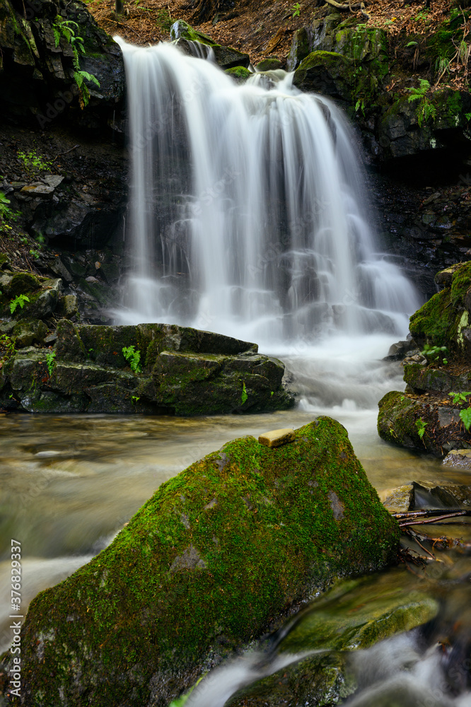 Wall mural Larger waterfall on the river in the forest.