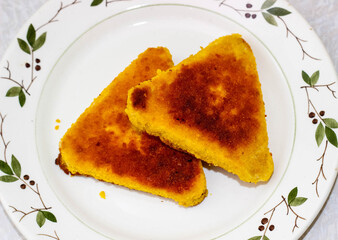 Two fried fish cutlets on a plate.