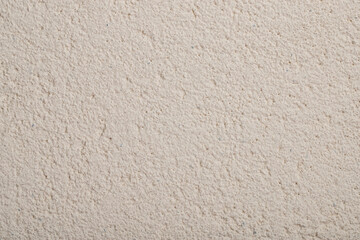 beige textured plaster on the wall of the house, background