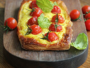 Fresh tomato tart, puff pastry topped with ricotta, cheese and cherry tomatoes