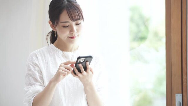 スマートフォンを操作している若い女性