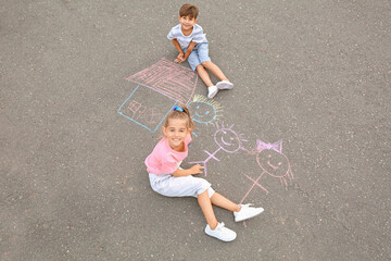 Naklejka premium Little children drawing with chalk on asphalt