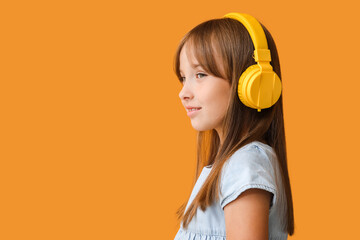 Little girl listening to music on color background