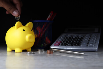 Yellow pig piggy bank is saving with coin money placed on desk (financial planning concept)