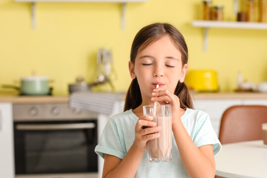 Little Girl Drinking Tasty Chocolate Milk At Home