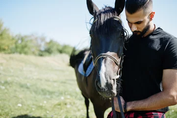 Foto op Canvas Arab tall beard man wear in black with arabian horse. © AS Photo Family