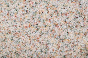 textural plaster of the house wall, colored granite chips, background