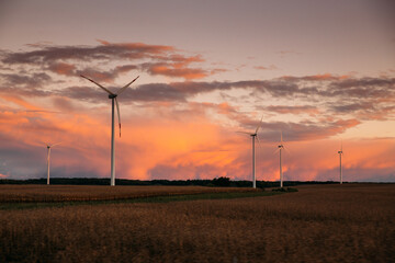 Fototapeta na wymiar Sunset over windmills. Innovative energy creator for electric power production.