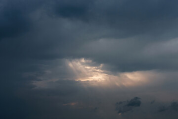 Rays of light shining through dark clouds, dramatic sky with cloud