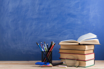 Education concept - books on the desk in the auditorium
