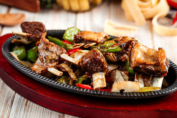 Roasted ribs meat with vegetables in cast iron pan