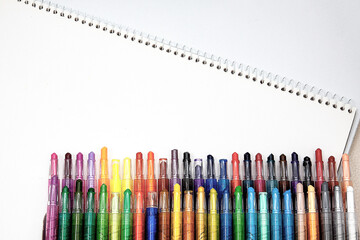 White-bottomed sketchbooks and various colored pencils