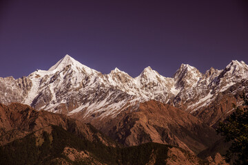 Obraz premium View of Snow cladded Panchchuli peaks falls in great Himalayan mountain range & alpine grass meadows enroute to Khalia Top trekk trail at small hamlet Munsiyari, Kumaon region, Uttarakhand, India.