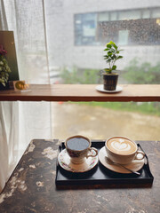 Cup of coffee on a rainy day window background.