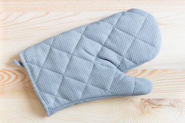 Glove for carry hot food when finish cooking from a microwave on natural wood background