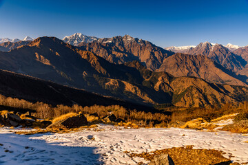 Panoramic view of Snow cladded  peaks falls in great Himalayan mountain range and alpine grass meadows at small hamlet Munsiyari, Kumaon region, Uttarakhand, India.