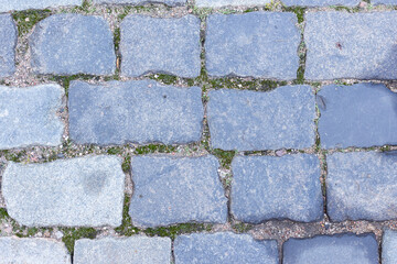 Gray, smooth granite paving stones. Paving stone background. An old road.
