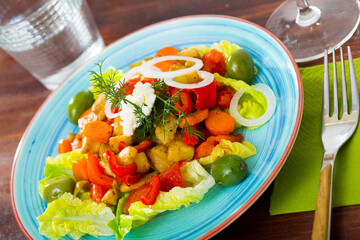 Colorful vitamin salad with baked eggplant, bell pepper, carrots, fresh lettuce and soft cheese