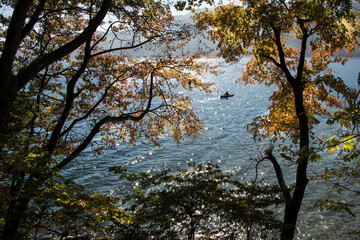紅葉した山に囲まれた湖面輝く湖