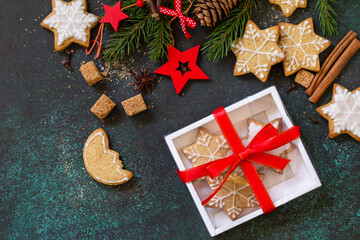 Christmas baking. Homemade Gingerbread cookies in a gift box on a stone or slate background. Top view flat lay background. Copy space.