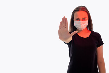 Stop gesture. Quarantine measures. Concerned woman in protective mask red glow showing forbidden hand. Looking at camera isolated on white copy space. Pandemic restriction. Keep distance