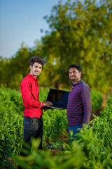 young agronomist analyzing field with farmer, indian farming