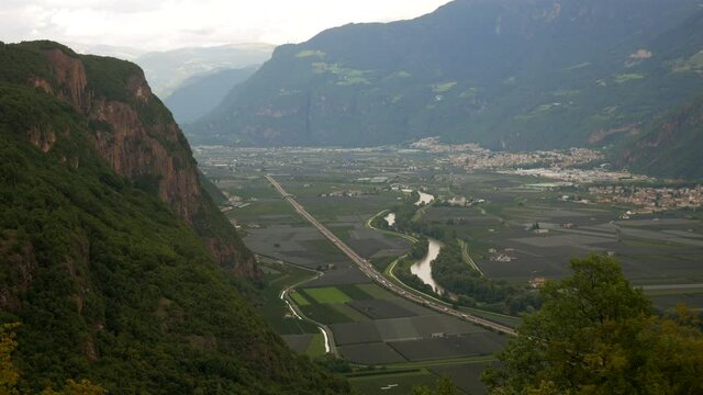 Rural landscape of mountains in Italy, Brenner motorway, Etsch river and Bozen City in background.Static wide shot.