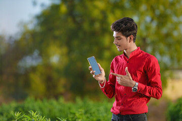 young indian agronomist with smartphone