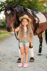 Obraz premium Friendship of a child with a horse. Treating autism with a horse. Interaction of a girl with autism and a horse. Walking a child with a horse in the fall.