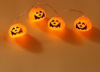 Halloween pumpkin lights on orange background with copy space. Halloween  concept.