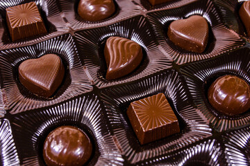 Heap of chocolate candies in a brown box